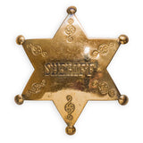 A solid brass sheriff's badge with an embossed 'SHERIFF' text in the center and decorative elements around the border.