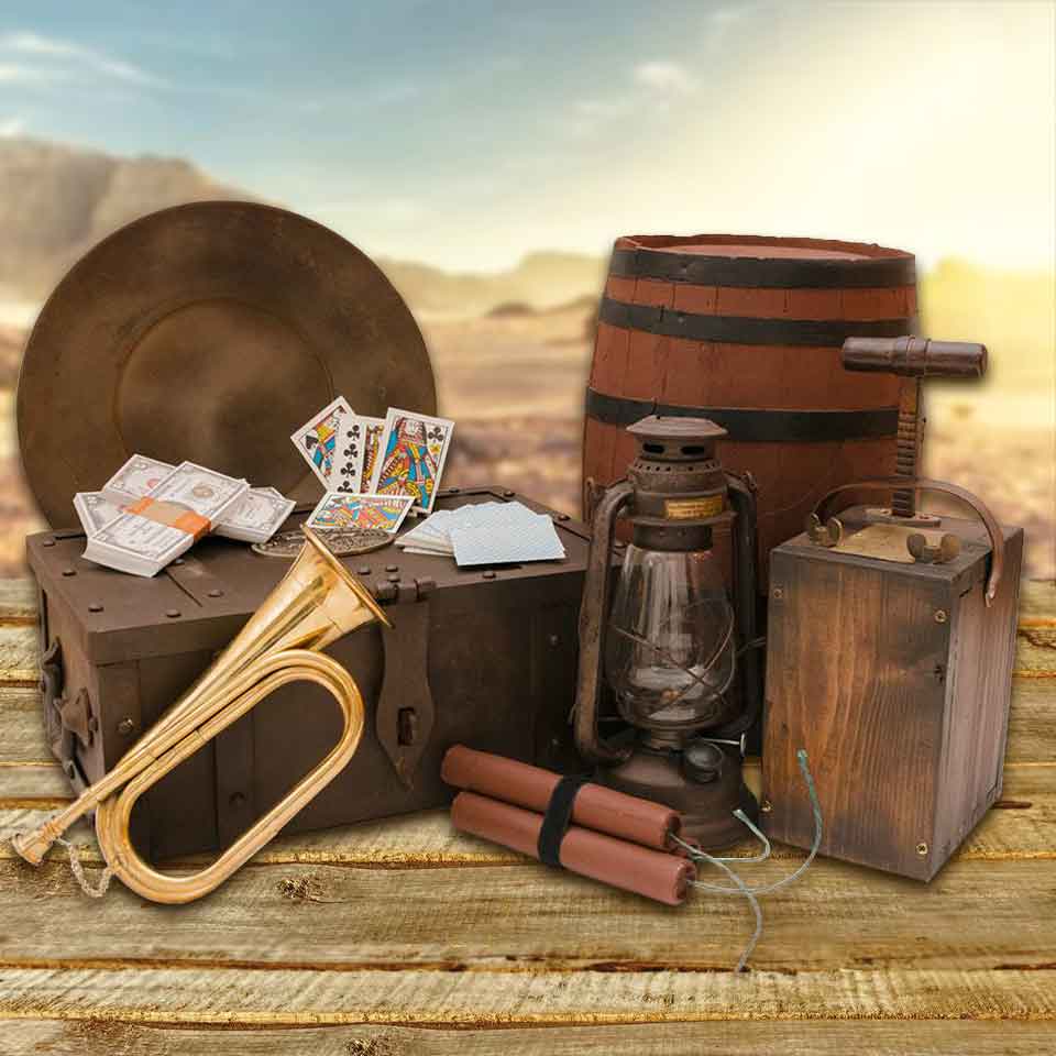 Pile of old west set props, brass bugle, lantern, tnt plunger, keg, mining pan, old money, and playing cards - category image.