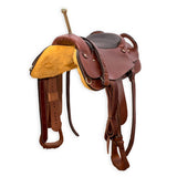 A brown trick riding saddle with a complete set of accessories including straps and hand holds, made in the USA.