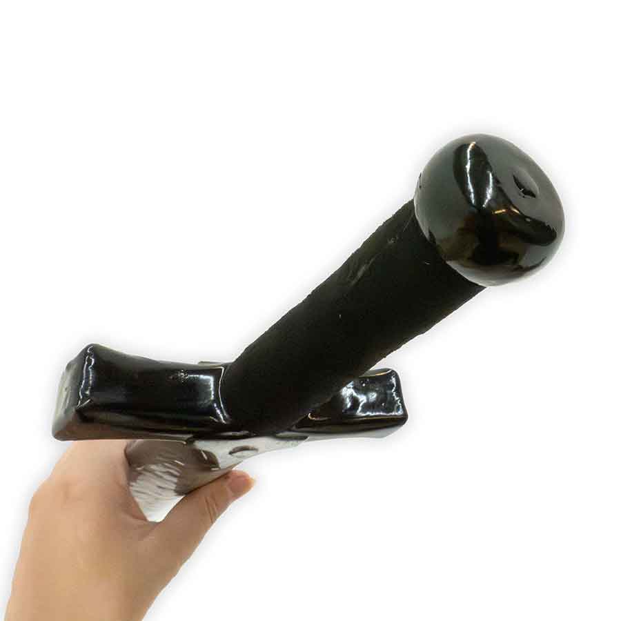 Black handle with a metallic finish held by a hand on a white background
