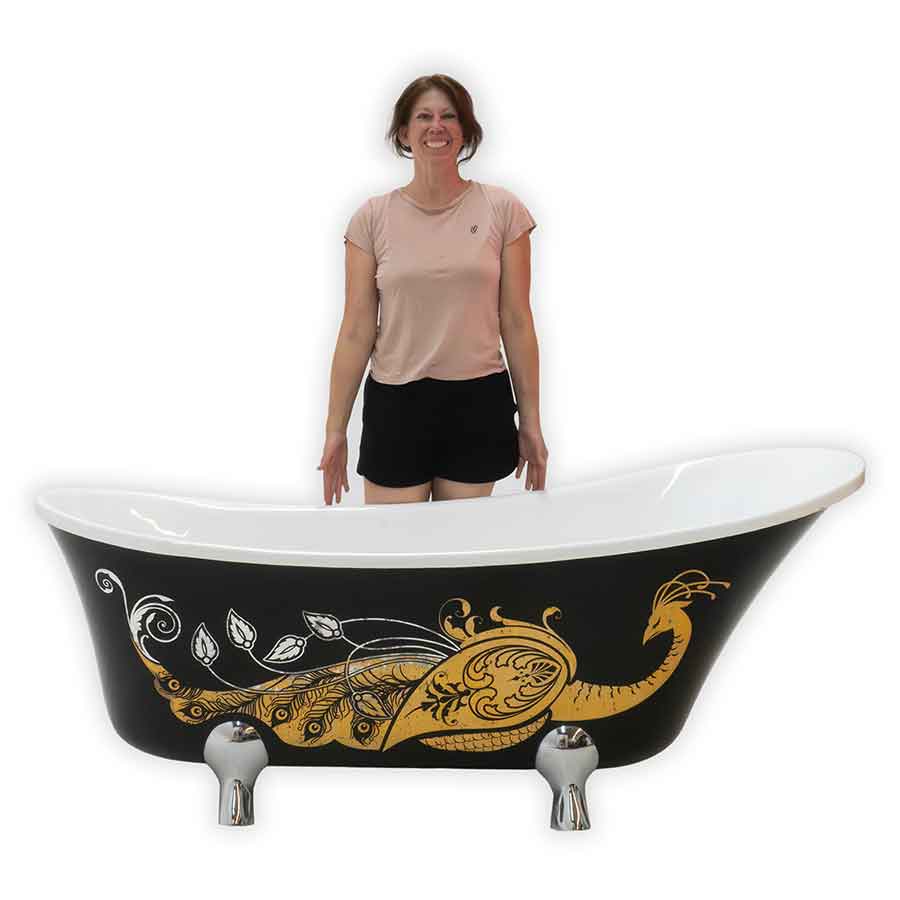 Woman standing next to a freestanding bathtub with decorative gold design on a white background