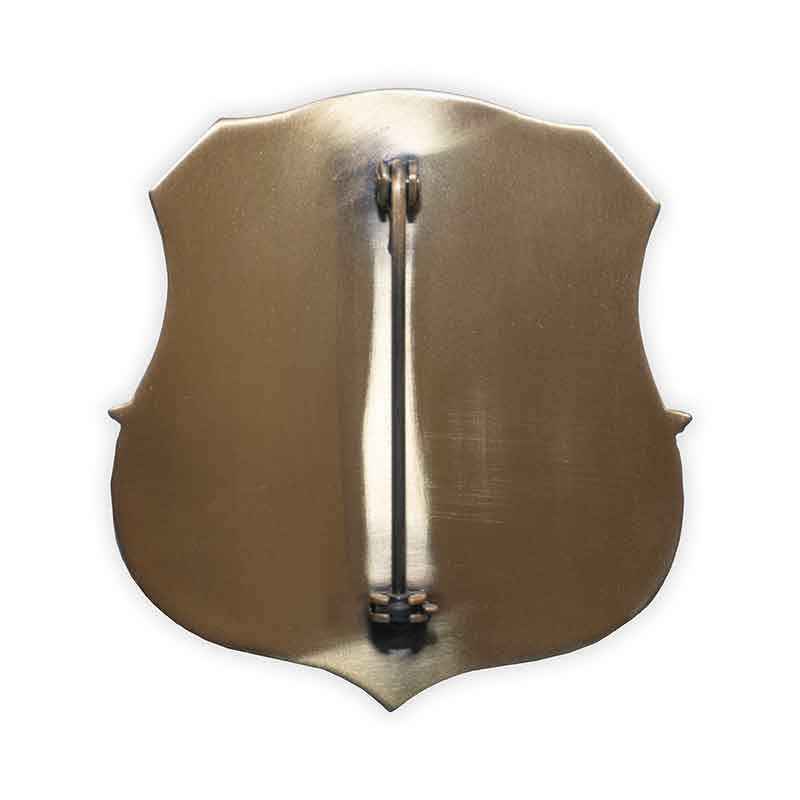 Metallic brooch shaped like a violin on a white background