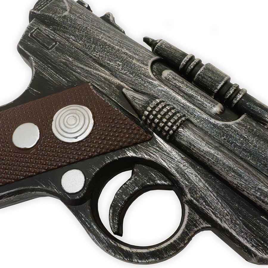 Close-up of a detailed model gun with brown grip and silver accents on a white background