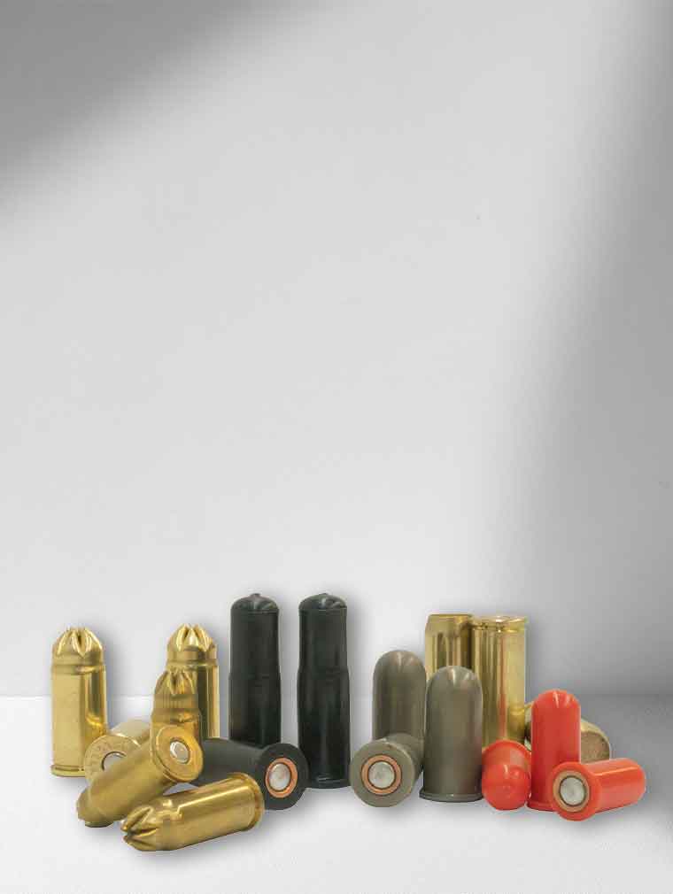 Collection of various revolver blank bullet-shaped objects on a gray background